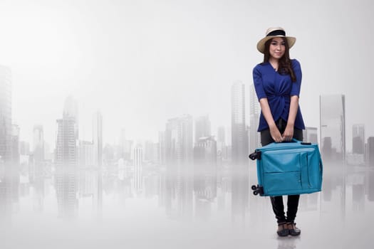 Pretty asian traveler woman carrying blue suitcase over futuristic background
