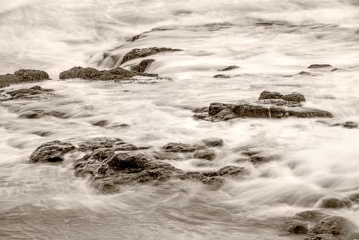 Surf of the Atlantic Ocean with rocks in long exposure