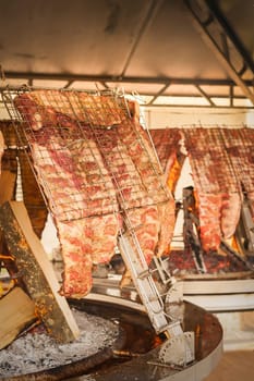 Asado, traditional barbecue dish in Argentina.  Roasted meat of beef cooked on a vertical grills placed around fire