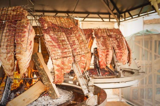 Asado, traditional barbecue dish in Argentina.  Roasted meat of beef cooked on a vertical grills placed around fire