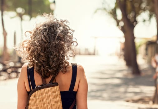 Woman seen from behind. Walking on a path toward an uncertain future but bright. Conceptual image.