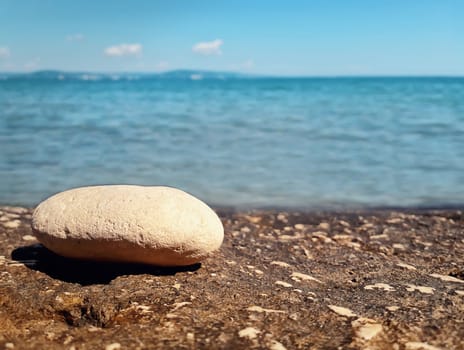 Closeup of pebble rock at the beach near the water. Journey, summer vacation concept