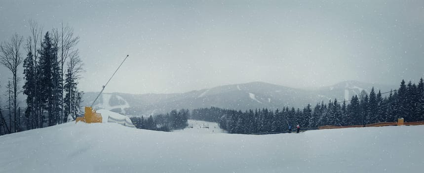 Snowing winter day on the ski slope. Perfect destination for a winter vacation in the peaks fir forests and ski slopes all covered by snow.