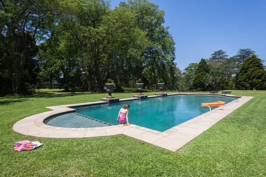 Summer day young girl swimming pool at  private home