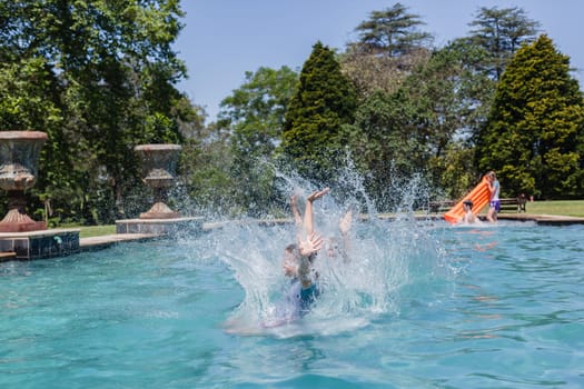 Girls running jumping into home  swimming pool summer playtime