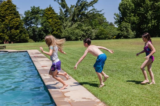 Girls boy running jumping into home  swimming pool summer playtime