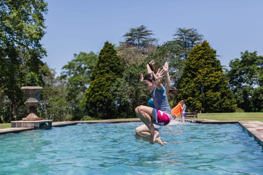 Girls running jumping into home  swimming pool summer playtime