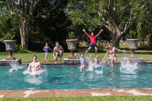 Girls boys running jumping into home  swimming pool summer playtime