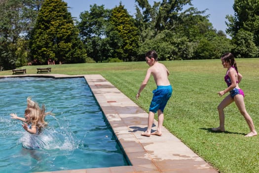 Girls boy running jumping into home  swimming pool summer playtime