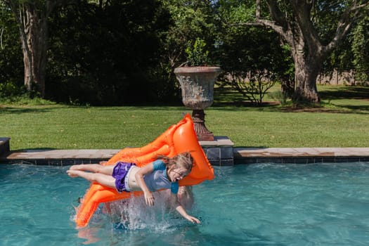 Girl Boy playing in swimming pool home summer