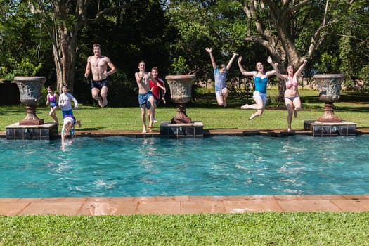 Girls boys teenagers young running jumping into home  swimming pool summer playtime