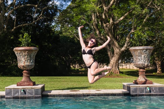 Girl running jumping into home  swimming pool summer playtime
