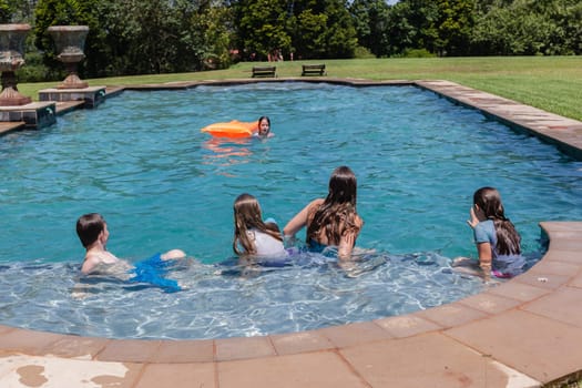 Girl, Boy playing in swimming pool home summer