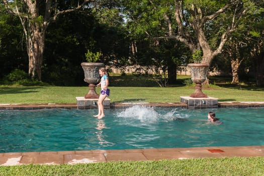 Girl Boy playing in swimming pool home summer