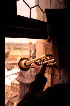 The tower blaeser at a trumpet signal on the tower of St. Mary's Church in the old town of Krakow in the south of Poland.