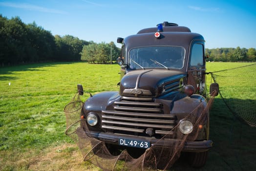 DENEKAMP, NETHERLANDS - SEPTEMBER 25, 2016: Vintage Ford koeln ambulance truck decorated with fishing nets
