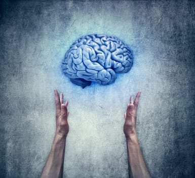 Intellectual protection. Closeup of two human hands holding a blue brain. Save intelligence and mental health concept