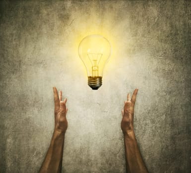 Closeup of two human hands holding a light bulb. Creativity and idea concept