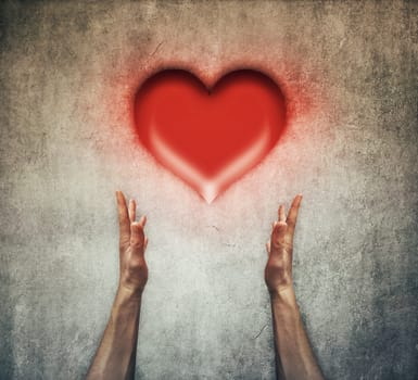 Closeup of two human hands holding a red heart. Healthcare and love concept