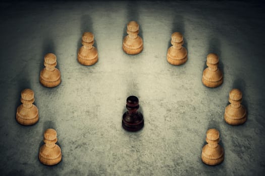 Black chess pawn piece surrounded by white ones joining their power together. Business group leadership and team working symbol. Racism or bullying concept