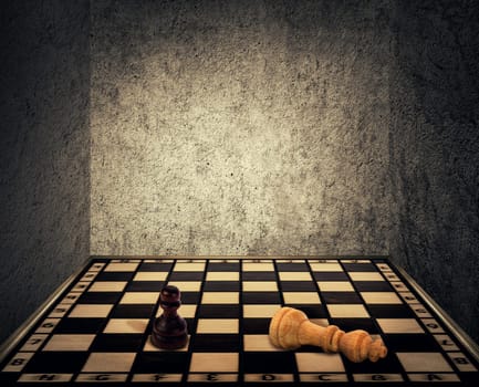 Magical room with a chess board floor surrounded by concrete walls as limitations and the king piece falling down beaten in front of the pawn figure. Business fail and mismanagement concept.