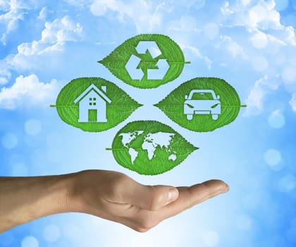 Opened hand holding a green leaf with recycling symbol on a blue sky background. Friendly environment and sustainable development and eco world concept