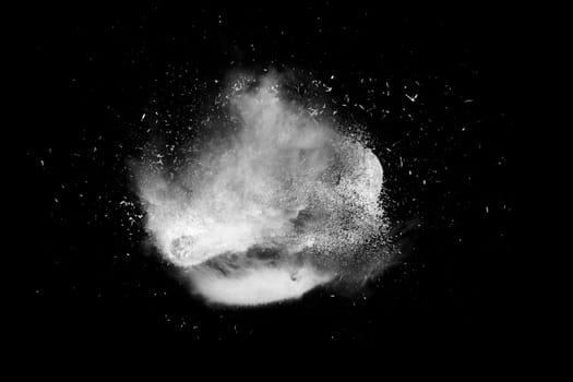 Freeze motion of white powder paint exploding isolated on black, dark background. Abstract design of color dust cloud. Particles explosion screen saver, wallpaper brush