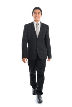 Full body front view portrait of attractive young Southeast Asian businessman walking, isolated on white background.