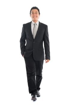 Full body front view portrait of young Southeast Asian businessman walking, isolated on white background.