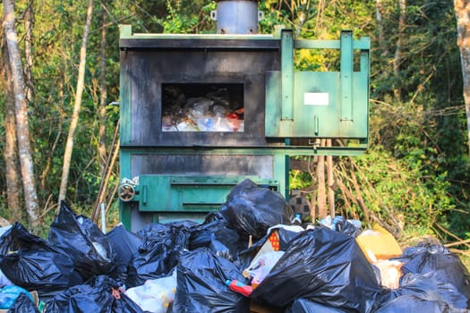 Incinerator in national park with garbage background