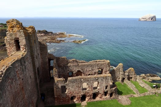 The castle ruins of Tantallon Castle with the island of Bass Rock in Scotland