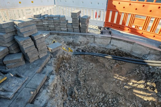 Construction site with stones and railings and cables with drainage made of gravel