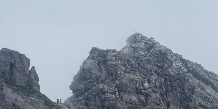 Hindelanger via ferrata with summit of the Wengenkopf in the fog and mountaineers