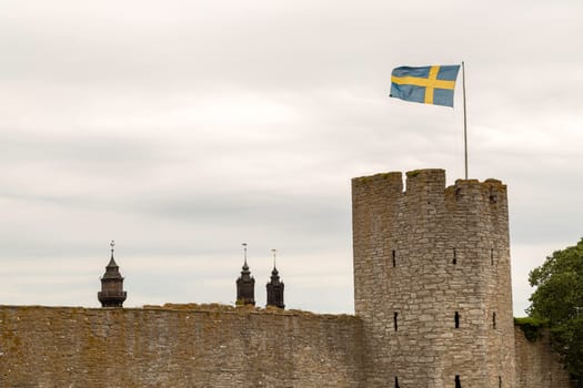 Town Wall in Visby, Gotland with the Swedish flag and the Visby Cathedral.