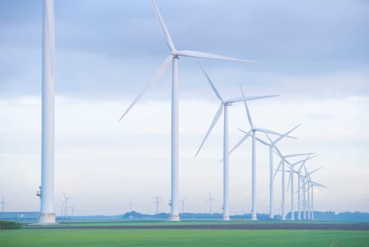 row of wind turbines in early morning in a flat dutch landscape