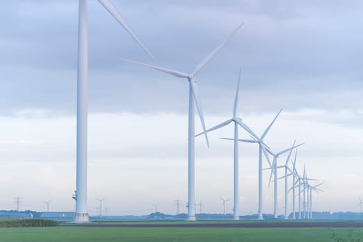 row of wind turbines in early morning in a flat dutch landscape