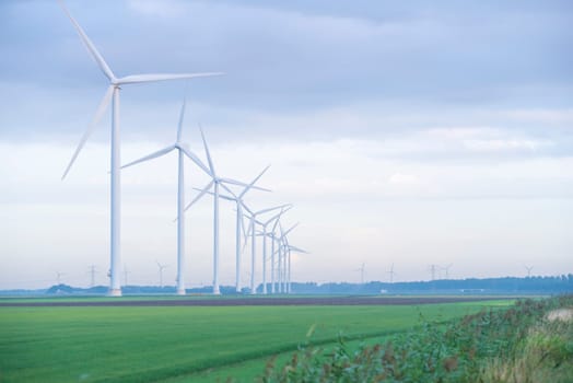 row of wind turbines in early morning in a flat dutch landscape