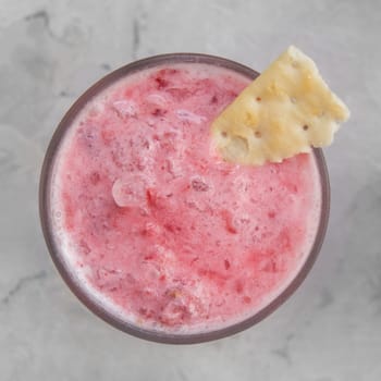 Strawberry smoothie with cookie on a white concrete background. Square cropping