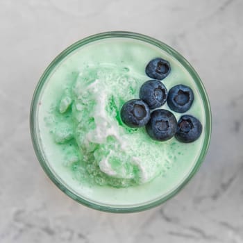 Blueberry smoothie on a white concrete background. Square cropping