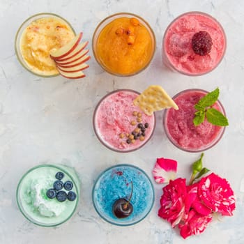 Different smoothie set on a white concrete background