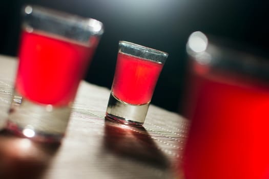 Alcoholic glasses with red alcoholic drink are on the table.
