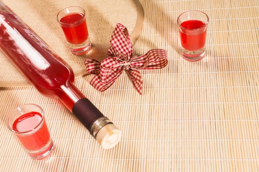 Bottle and glasses for alcohol are on natural background.
