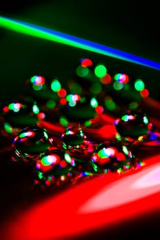 Colorful water drops are on dark abstract background.