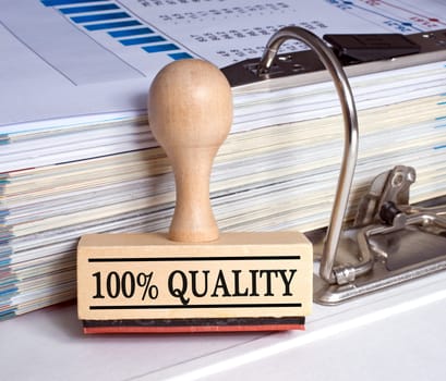 100 Percent Quality - Stamp with binder in the office