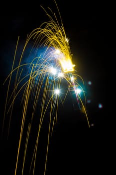 The yellow sparkler is on black background.