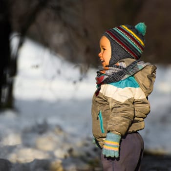 Little child is laughing outdoor at winter.