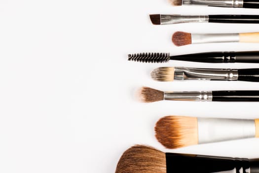 Different make up brushes are on white background.