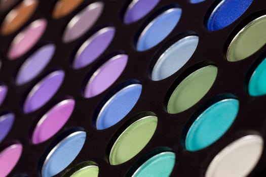Eye shadow palette with cold colors on black background.