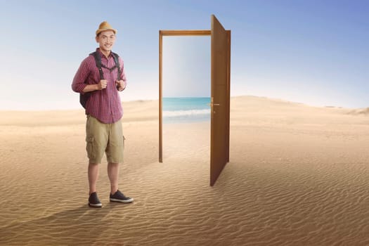 Traveler asian man going to beach on the open door at desert