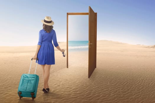 Tourist asian woman going to beach on the open door at desert